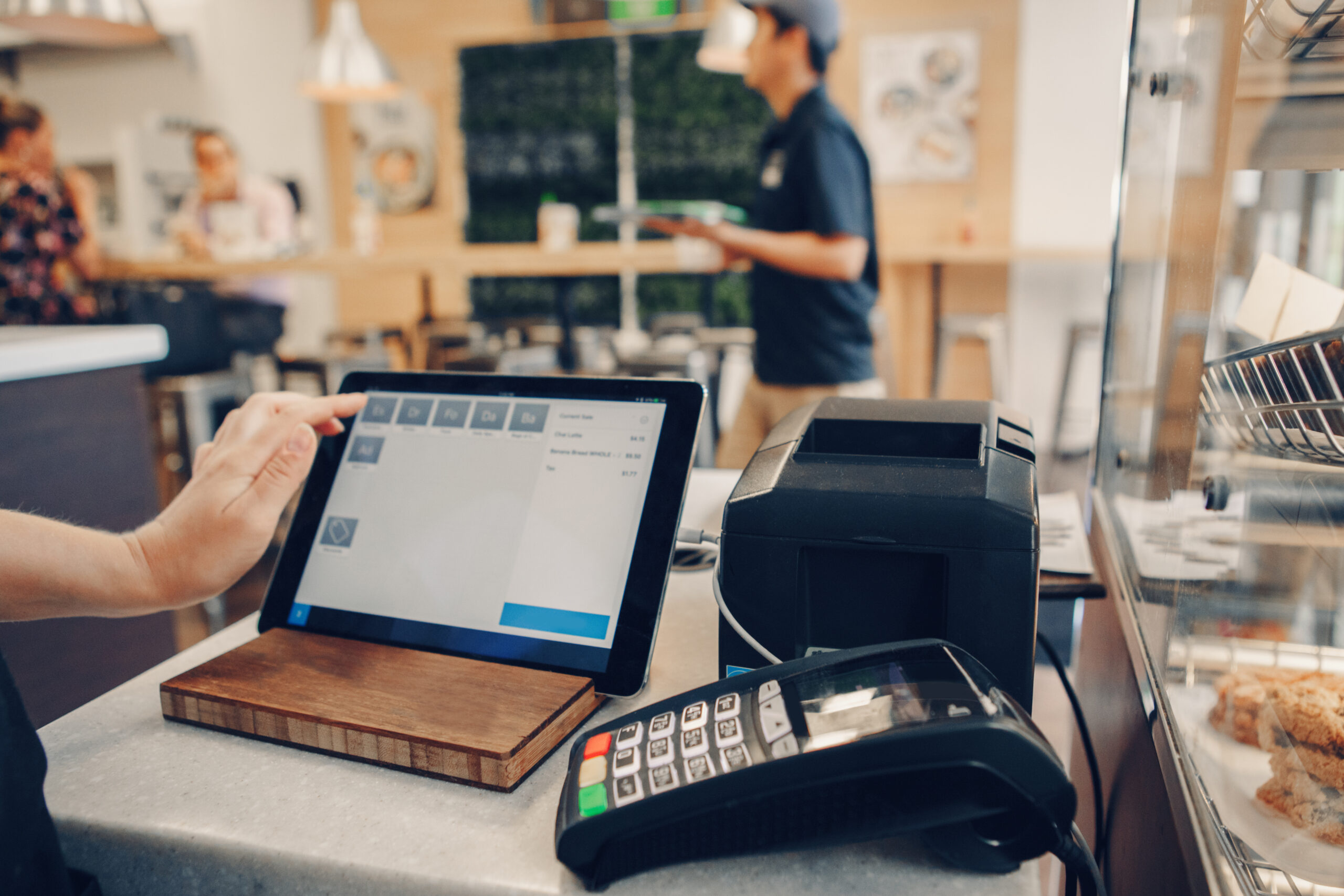 Closeup shot of caucasian cashier hands. Seller using touch pad for accepting client customer payment. Small business of coffee shop cafeteria.
