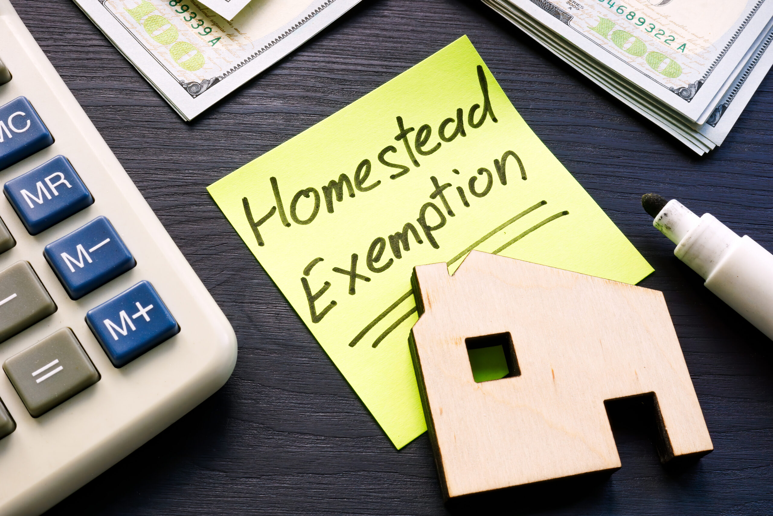 Homestead exemption sticker on a small model house representing property tax savings