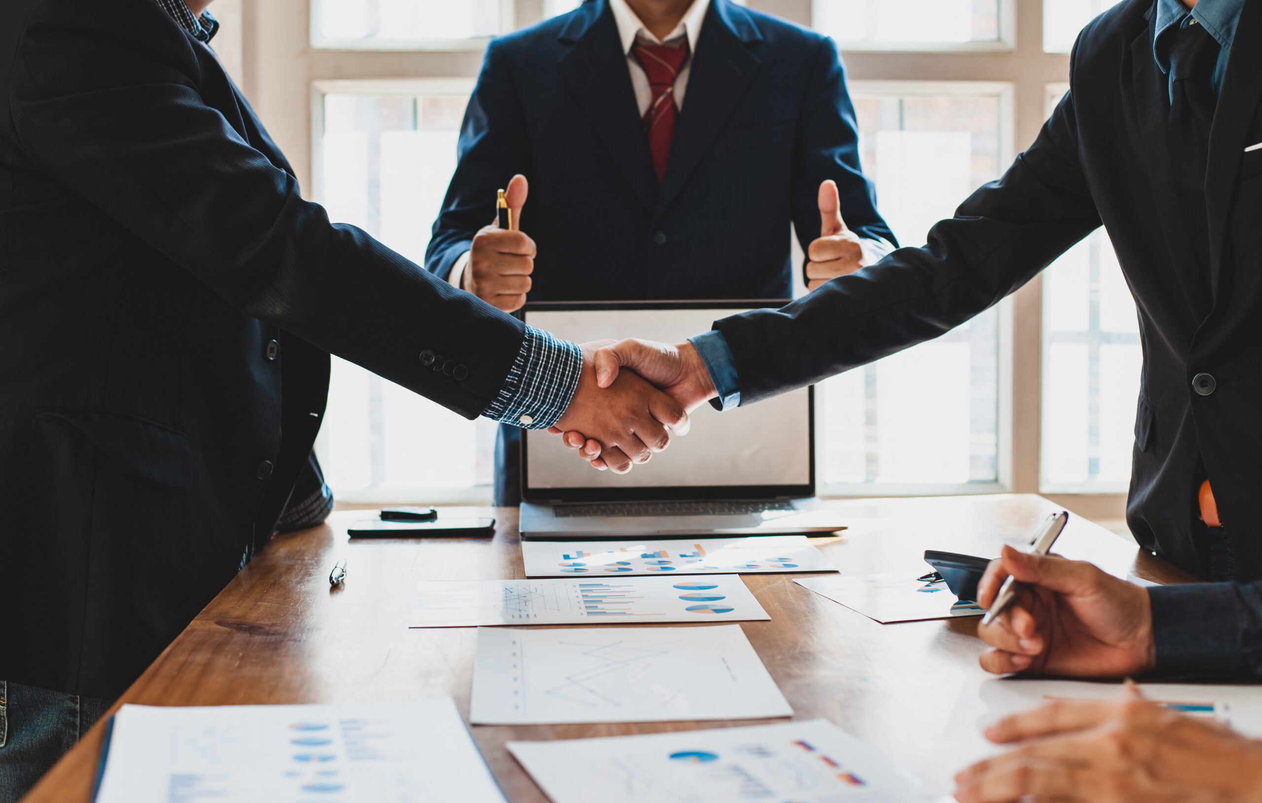 Business partners shaking hands during a dispute resolution and mediation meeting